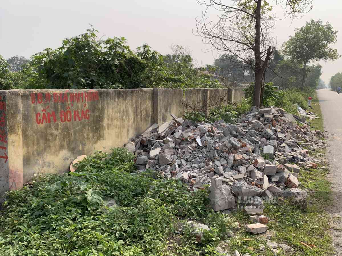 Phía bên ngoài bãi rác, rác thải xây dựng, rác sinh hoạt tràn lan bên vệ đuờng. Ảnh: Hà Vi