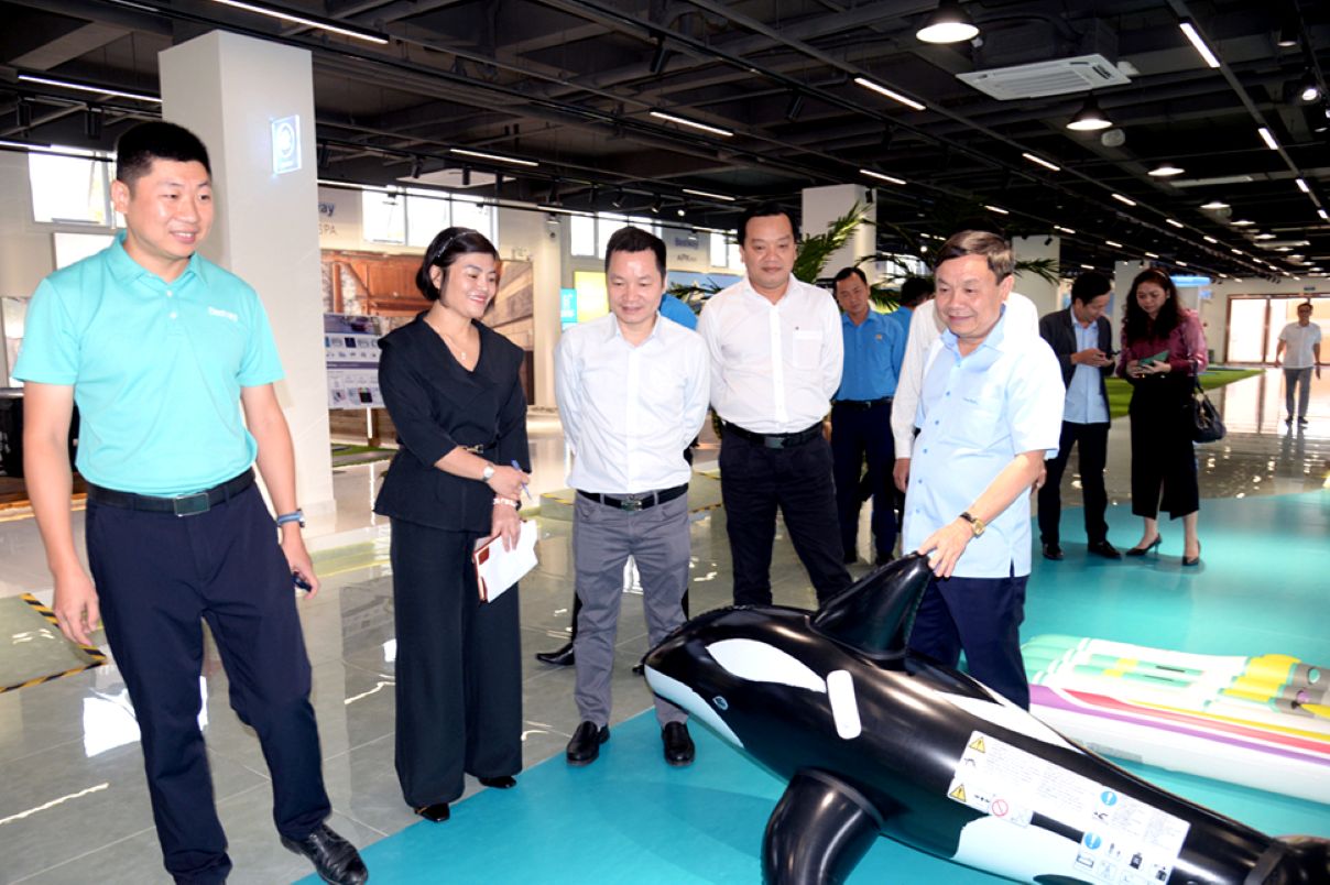 Ong Phan Van Thang (hang dau tu phai sang) tim hieu hoat dong san xuat tai Cong ty TNHH San pham the thao giai tri BestWay Viet Nam. Anh: Cong thong tin dien tu tinh Dong Thap