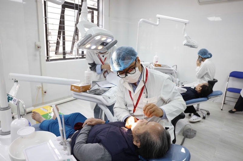 Hanoi is moving towards each commune and ward health station being supported by a hospital. In the photo are dental and maxillofacial specialists examining people. Photo: BVCC