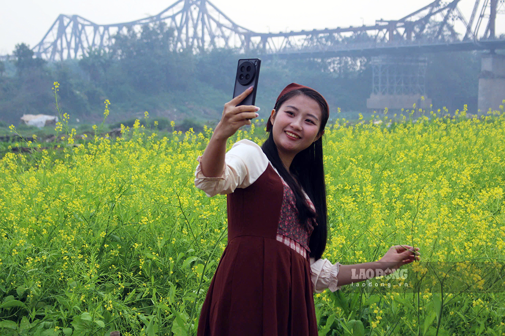 Chi Lan Huong (27 tuoi, Ha Noi) cho biet, day la lan thu ba chi toi ben hoa chup anh. “Toi thuc day chuan bi tu 5 gio sang, thay hai bo trang phuc de san khoanh khac binh minh tai ben hoa duoi chan cau Long Bien. Giua long Thu do co khong gian hoa ruc ro nhu nay, vua de chup anh, vua de thu gian rat dang quy”. 