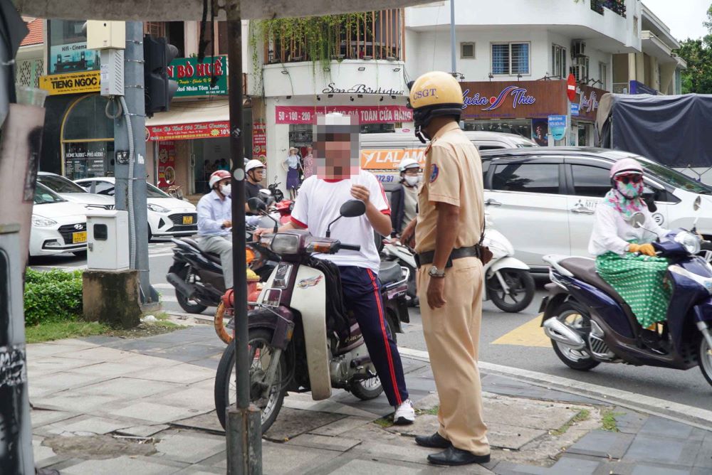 Students riding motorbikes when they are not old enough are fined by Ho Chi Minh City traffic police. Photo: Chan Phuc