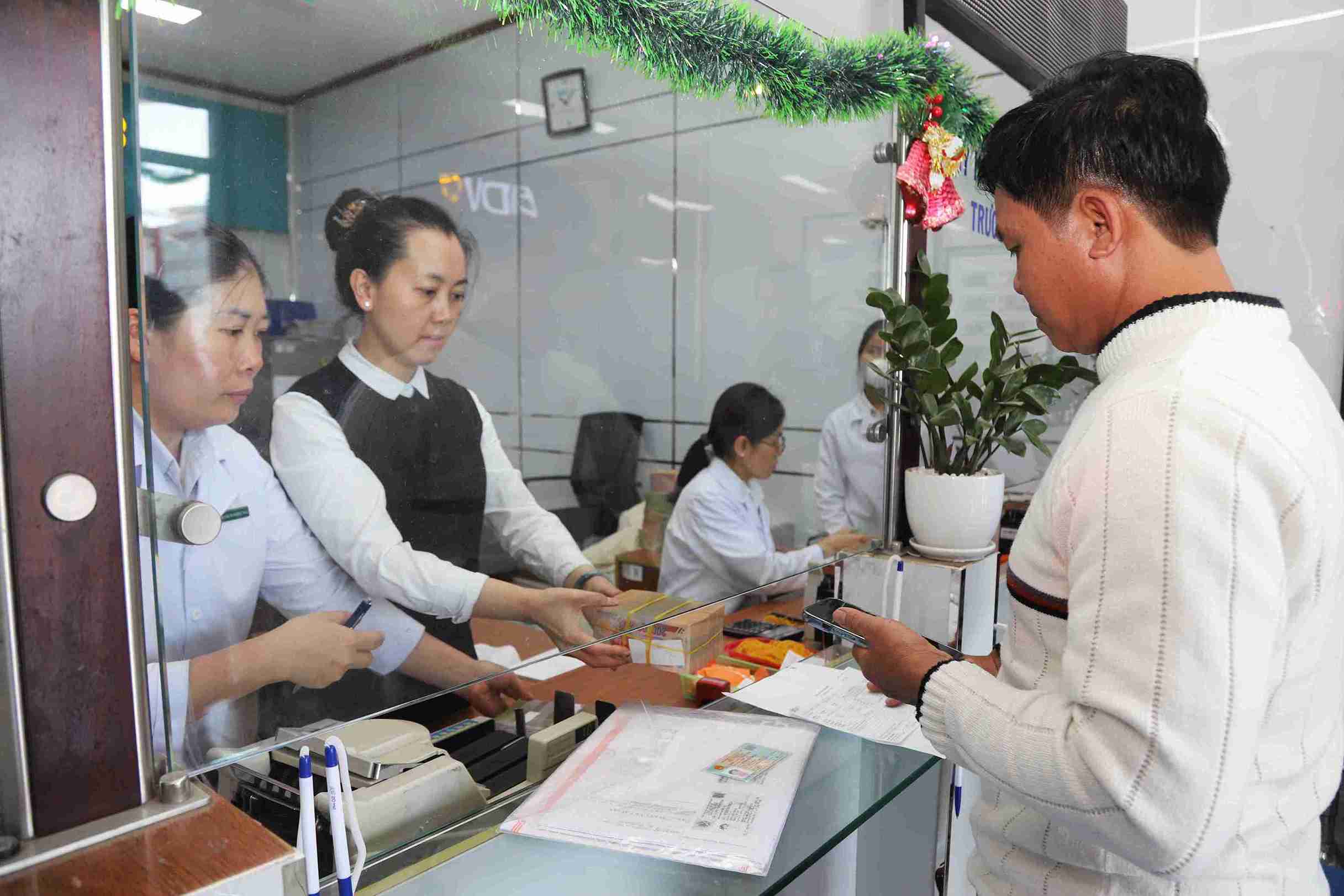 Nguoi dan nhan chi tra tien boi thuong tai Ngan hang BIDV chi nhanh Khu vuc Bao Loc. Anh: Phuc Khanh