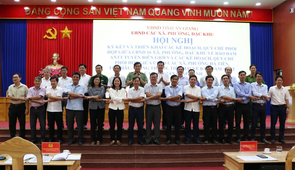 Representatives of leaders of People's Committees of communes, wards, and special zones sign plans and regulations to coordinate in ensuring security and order on the border line. Photo: Tien Dung