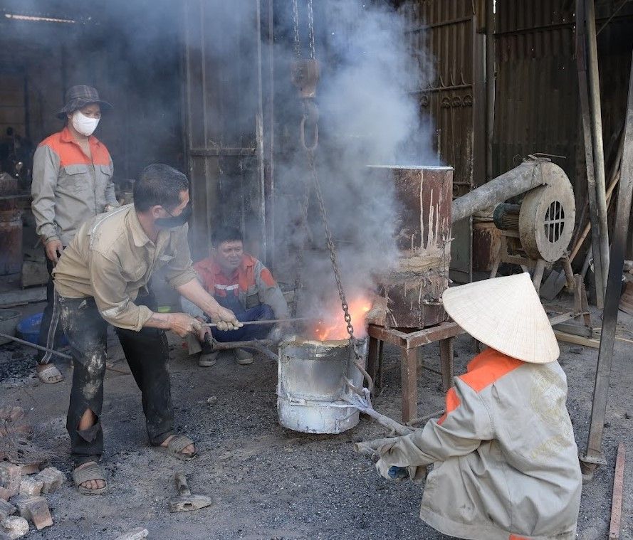 Nhung nguoi tho tai lang nghe duc dong Y Yen thuc hien cong doan rot dong da nung chay vao khuon. Anh: Nguyen Truong