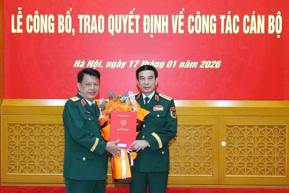 El General Phan Van Giang entrega la decision de ascenso al rango de General de Division al Coronel del Ejercito Dinh Hong Tieng - Comandante del Comando Militar Provincial de Lam Dong. Foto: Ministerio de Defensa Nacional