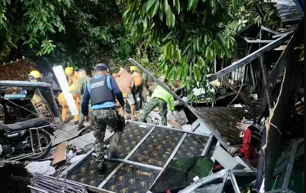 Luc luong cuu ho tim kiem trong dong do nat cua can nha bi sat lo da pha huy. Anh: Canh sat Philippines