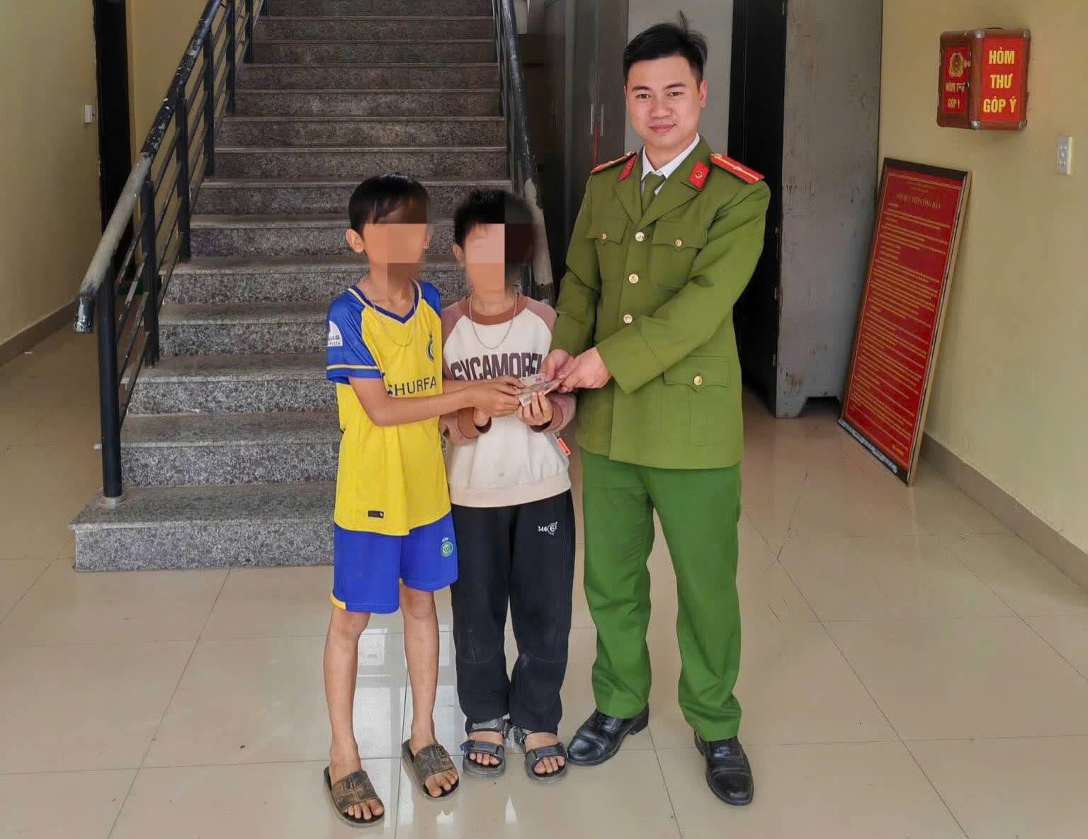 돈을 주운 학생이 떨어뜨린 사람을 찾아 공안으로 가져갑니다. 사진: 퐁냐 공안