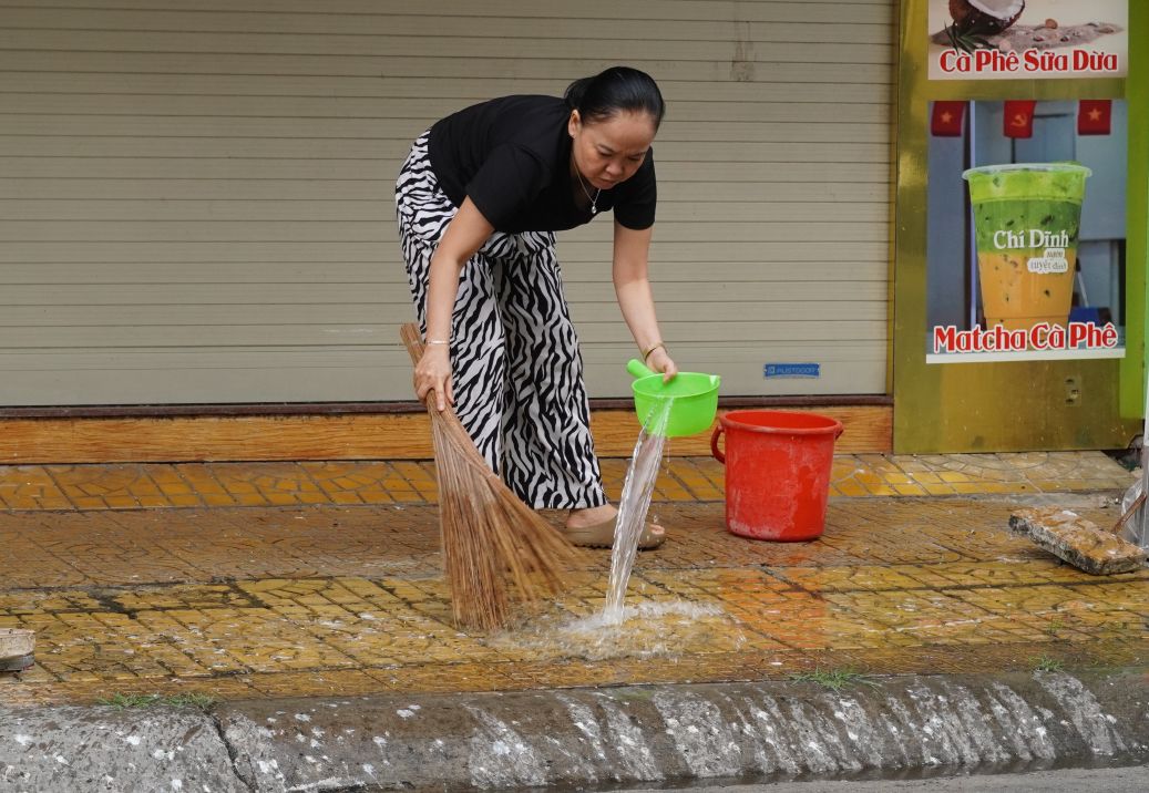 Người dân phải thường xuyên rửa vỉa hè để hạn chế mùi hôi do phân chim gây ra. Ảnh: Phương Anh