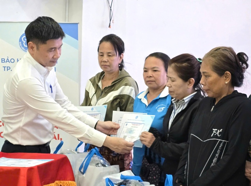 Mr. Tran Dung Ha - Deputy Director of Ho Chi Minh City Social Insurance - presents health insurance cards to women in difficult circumstances. Photo: Nam Duong