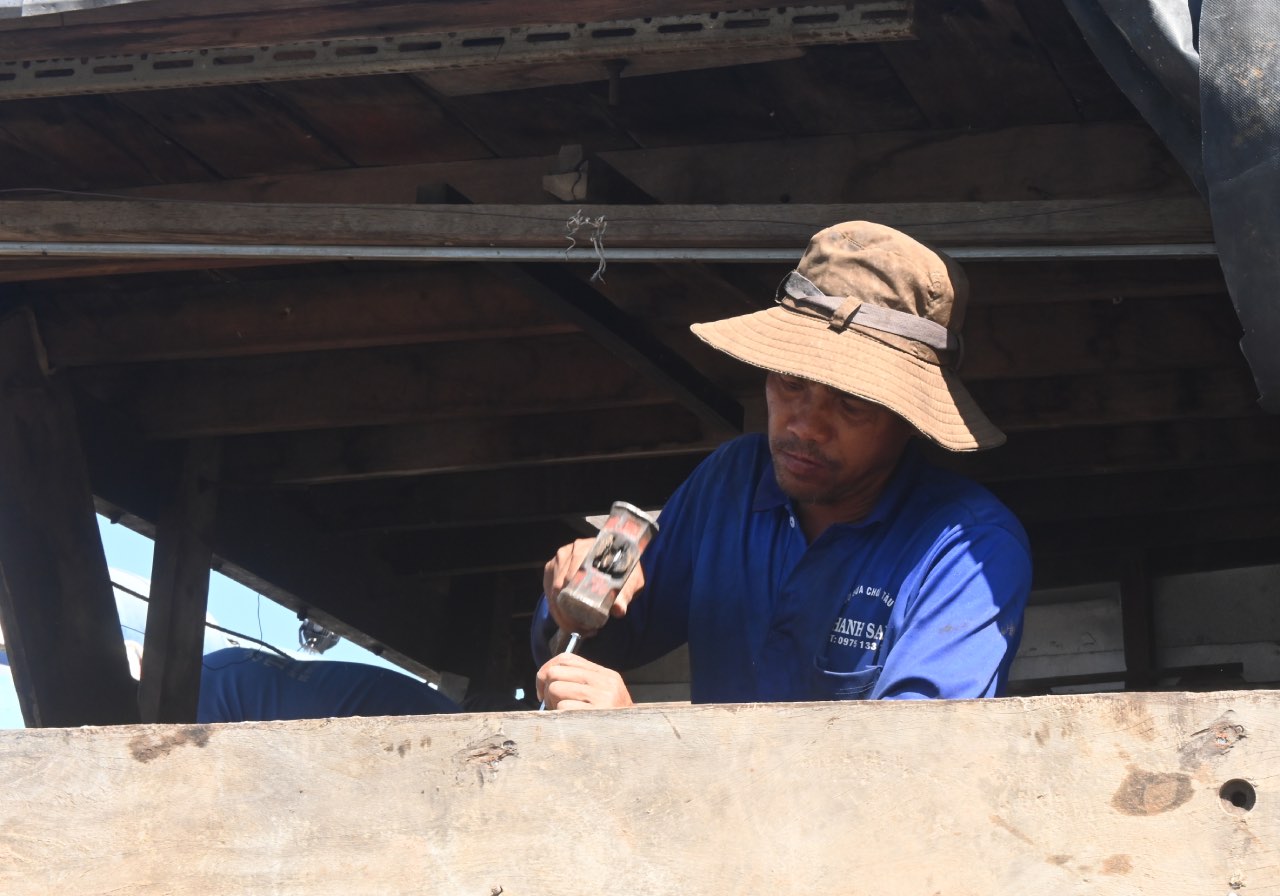 Nguoi tho dong ghe cam cui do, duc tung tam van go. Anh: Thanh Nhan