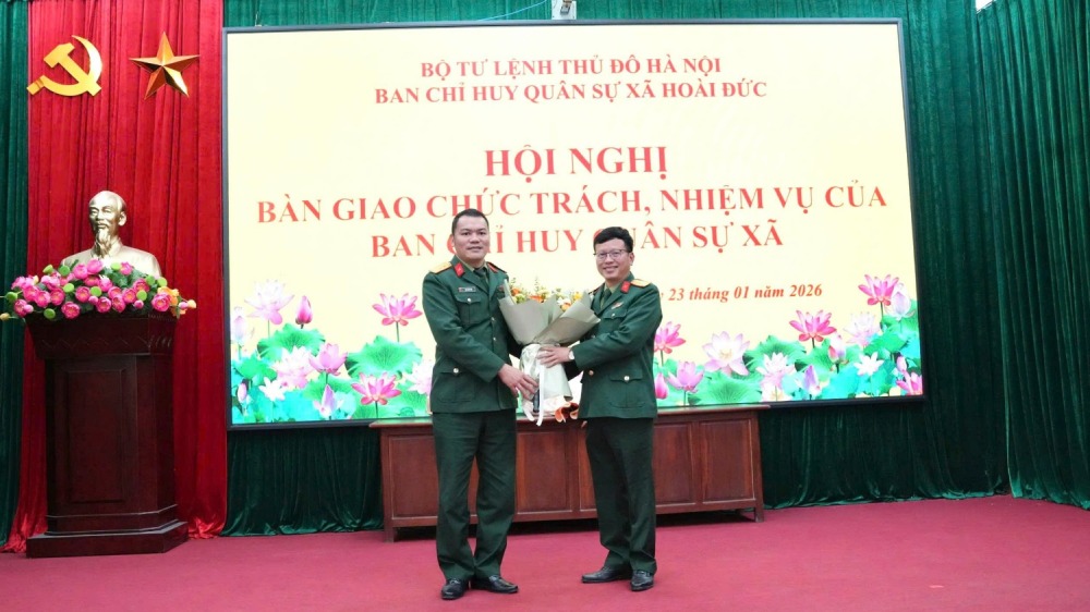 Le lieutenant-colonel Dinh Cong Vien - chef adjoint du commandement de la defense de la zone 2 - Phuc Tho (Hanoï) porte des fleurs pour souhaiter au lieutenant-colonel Tràn Quoc Dat - commandant en chef du commandement militaire de la commune de Hoai Duoc une nouvelle mission. Photo: hoaiduc.hanoi.gov.vn