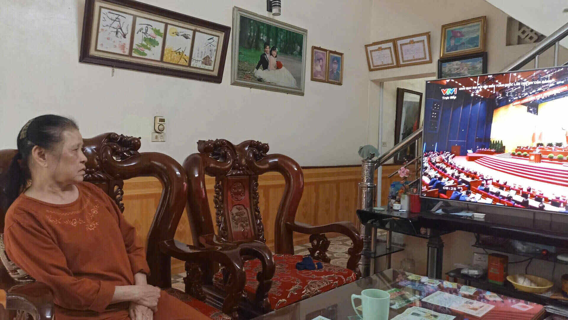 Ba Ba Hoang Thi Bao (76 tuoi) tru tai to dan pho Bac Thanh, phuong Hoa Lu, tinh Ninh Binh cham chu theo doi le khai mac Dai hoi XIV cua Dang. Anh: Nguyen Truong