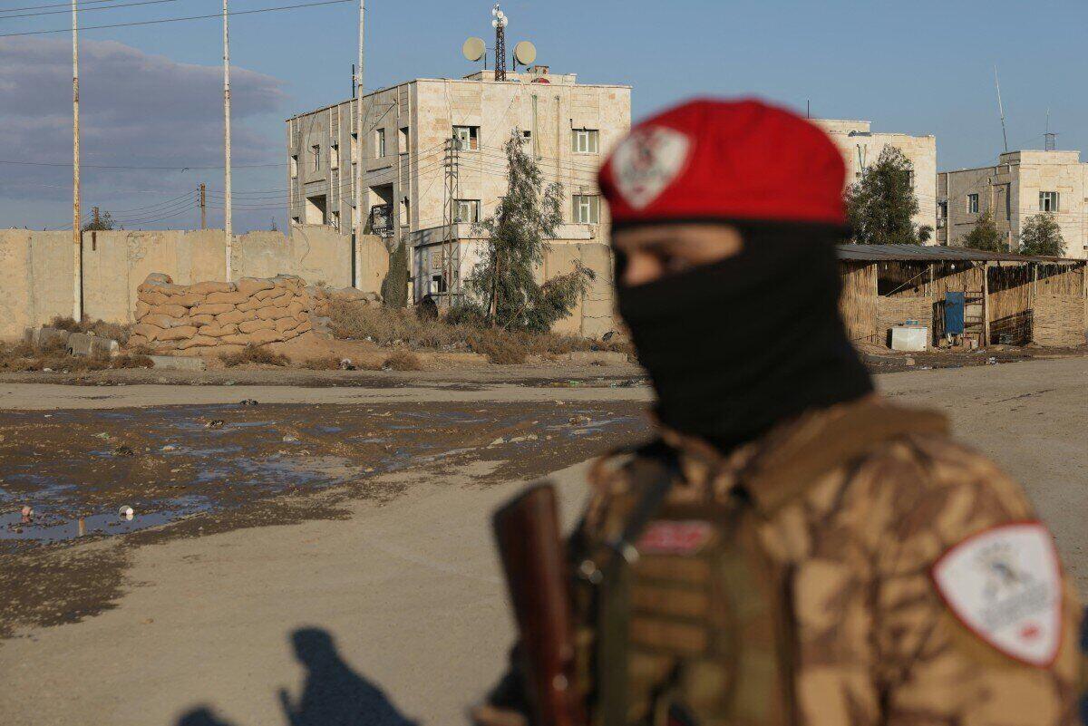 A Syrian government soldier stands outside Al Aktan prison controlled by the Syrian Democratic Forces (SDF), where IS prisoners are being held. Photo: AFP