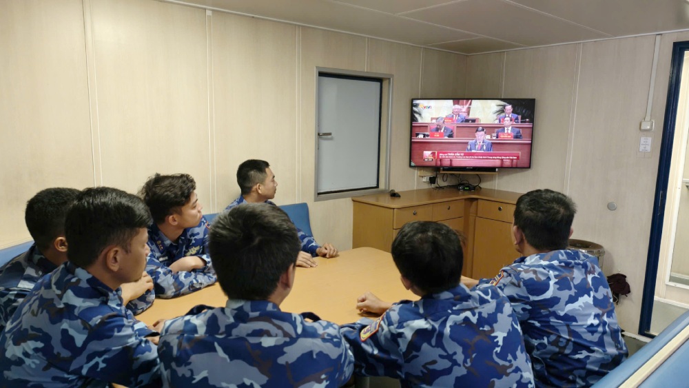 Officers and soldiers of Coast Guard ship CSB 9003, Flotilla 401, Coast Guard Region 4 Command watch the Opening of the 14th Party Congress at sea. Photo: Duc Thai