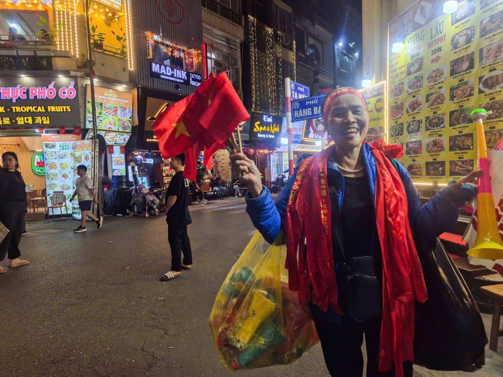 Doc cac tuyen pho trung tam Ha Noi, nhieu nguoi tranh thu bay ban co, bang ron va cac vat dung co vu, gop phan lam khong khi truoc tran Viet Nam – Trung Quoc them soi dong.  Anh: Phan Anh