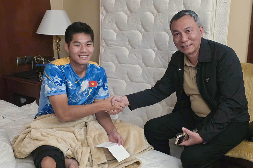 VFF President Tran Quoc Tuan encourages central defender Nguyen Hieu Minh after a serious injury. Photo: VFF