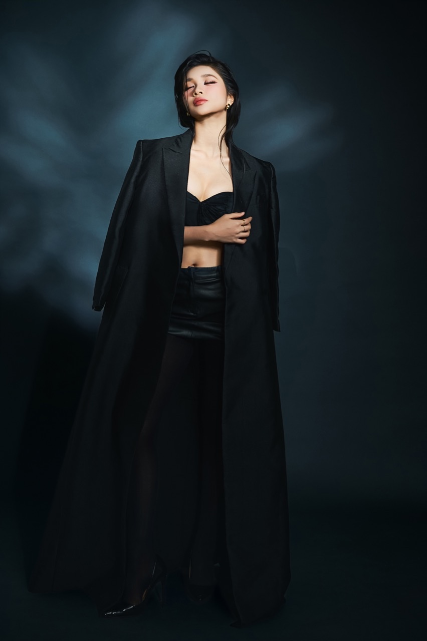 Trai nguoc voi hinh anh diu dang, layout thu hai mang den mot Minh Kien hoan toan khac – ca tinh va hien dai. Ao cup nguc om sat giup ton len voc dang, ket hop blazer khoac ho tren vai tao nen su doi lap thu vi giua net goi cam va phong thai manh me, tu tin. Qua tung khung hinh, Minh Kien the hien anh nhin sac sao, phong thai diem tinh va khi chat cua mot co gai tre hieu ro gia tri ban than.  