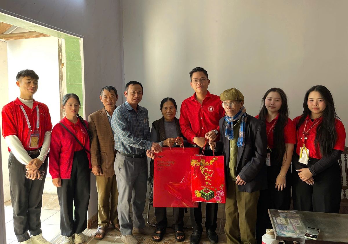 Cac tinh nguyen vien trao tan tay qua Tet tang cac gia dinh. Ảnh: Tieu Vu