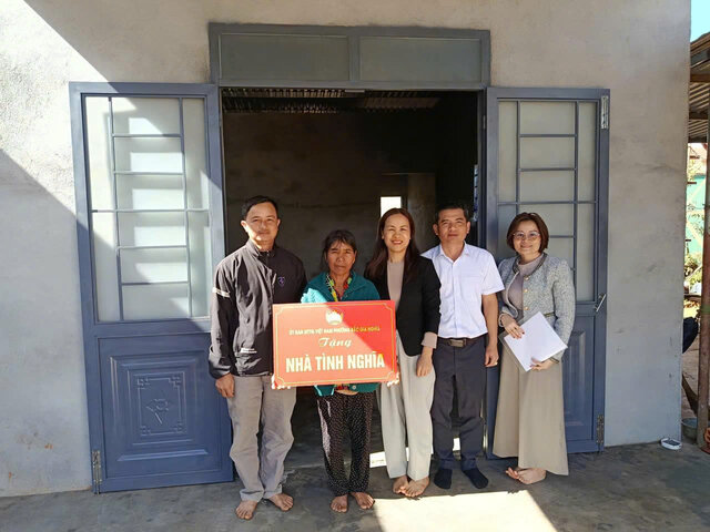 Mme Ta Thi Cham - Presidente du Comite du Front de la Patrie du quartier de Bac Gia Nghia (au milieu) remet des "Maisons de la gratitude" aux menages pauvres, en signe de bienvenue au XIVe Congres du Parti. Photo: Duc Lam