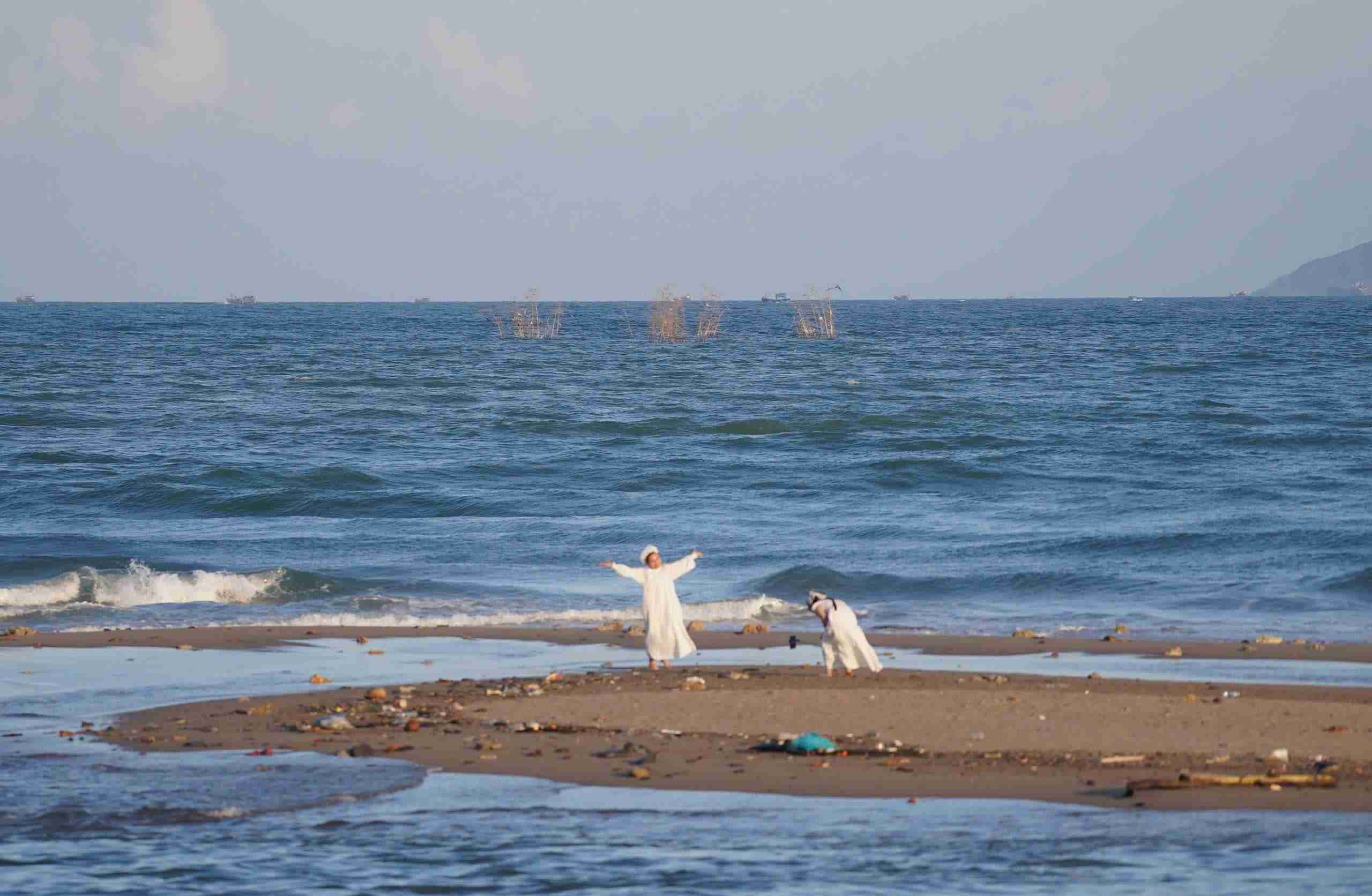 Du khach chup anh tai con cat gan bui tre moc giua bien Nha Trang. Anh: Huu Long