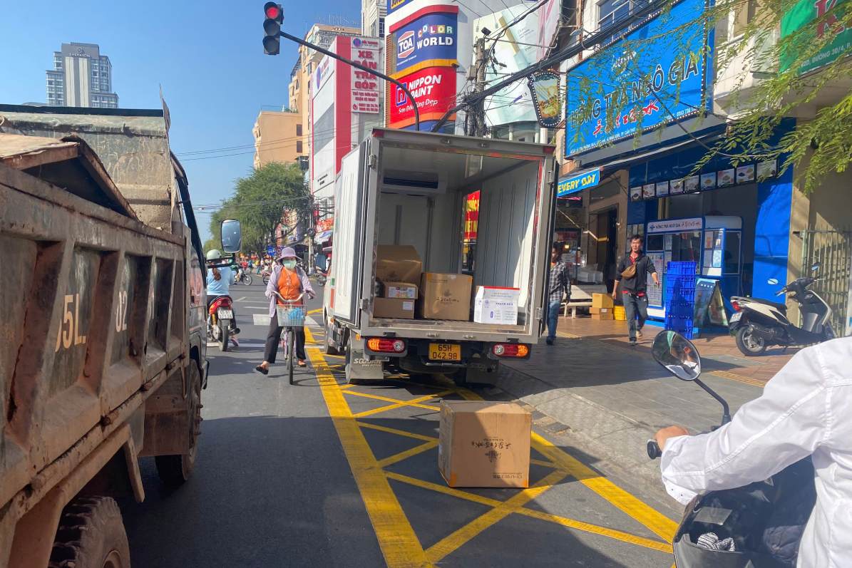 Van con tinh trang phuong tien ngang nhien dung, do xe tren vach mat vong de boc xep, van chuyen hang hoa. Anh: Ta Quang