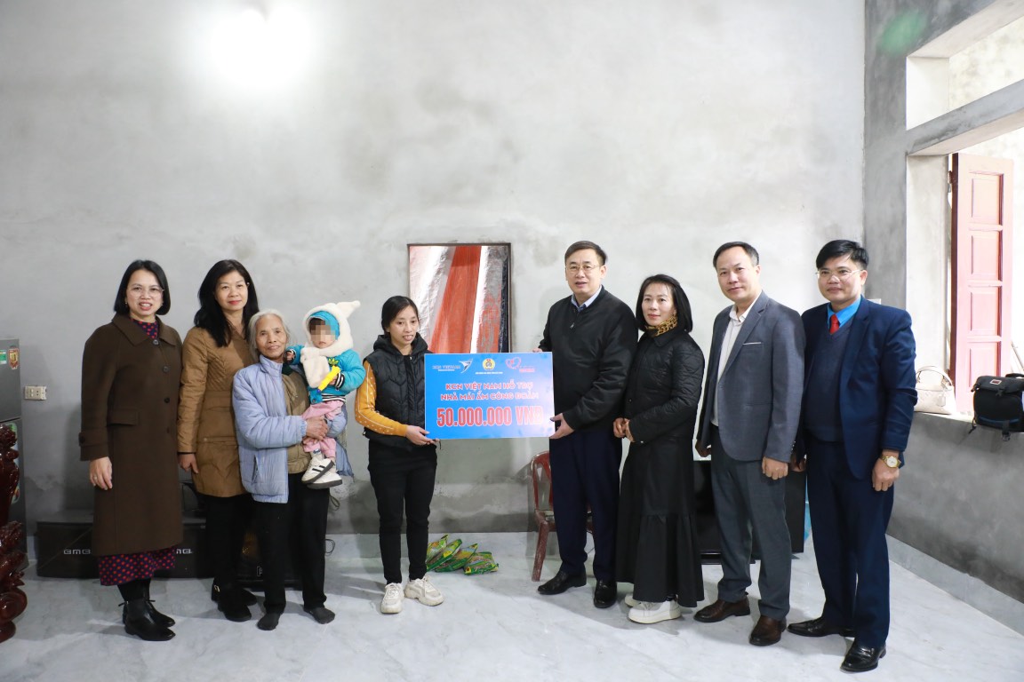 Chairman of Bac Ninh Provincial Labor Federation Thach Van Chung (4th from right) presents support for building a Trade Union Shelter house to Ms. Nguyen Thi Lieu. Photo: Ngoc Quyen