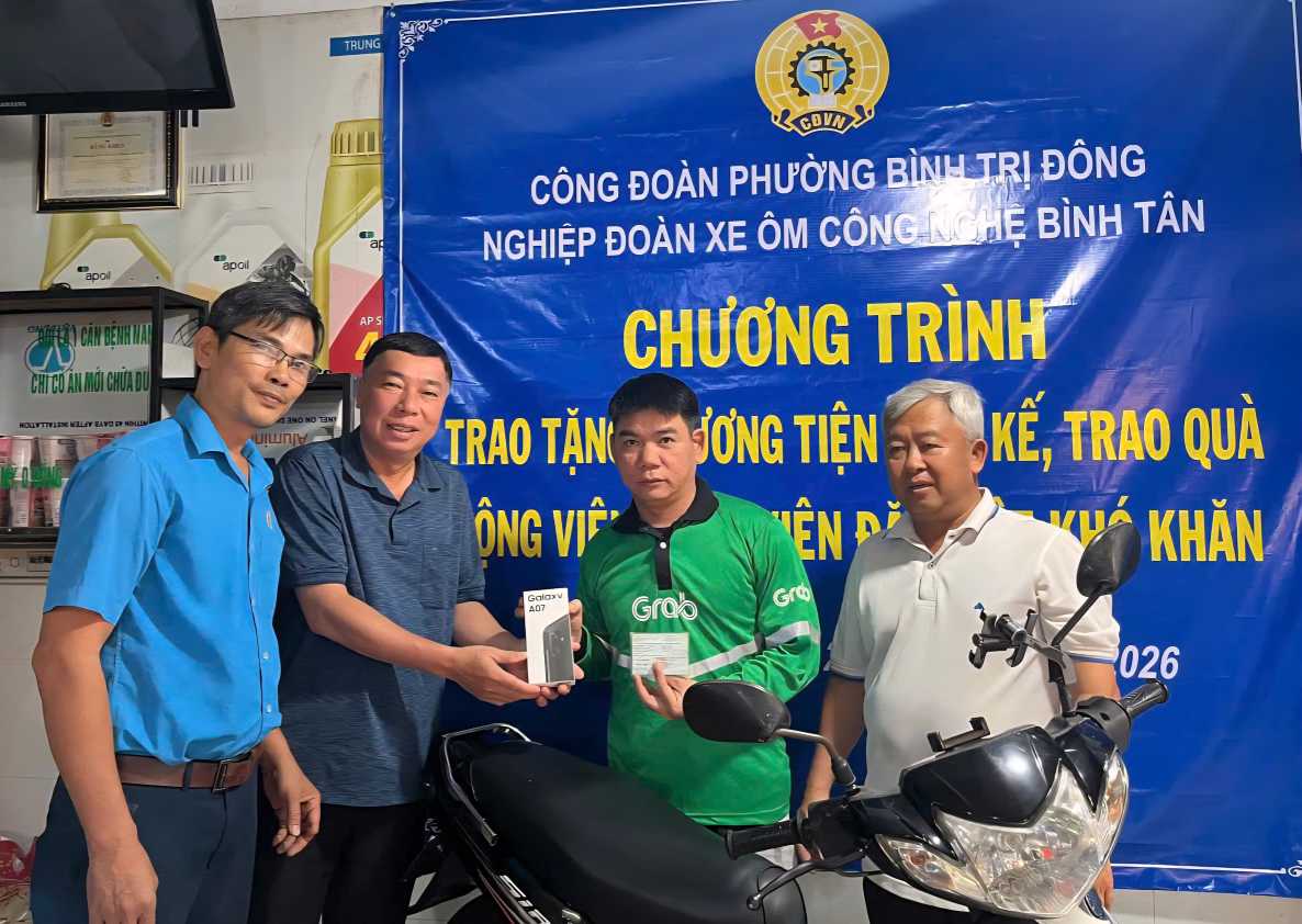 Les representants du syndicat des moto-taxis technologiques de Binh Tan et les responsables syndicaux remettent des motos aux membres du syndicat en difficulte. Photo: Duc Long