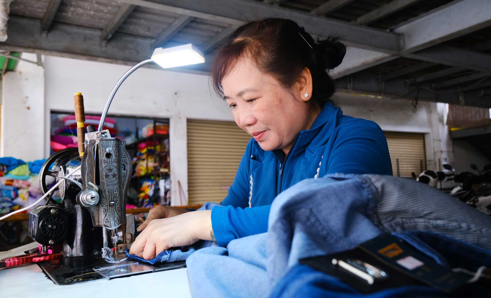 Chi Luu ti mi chinh sua quan ao cho khach. Anh: My Ly