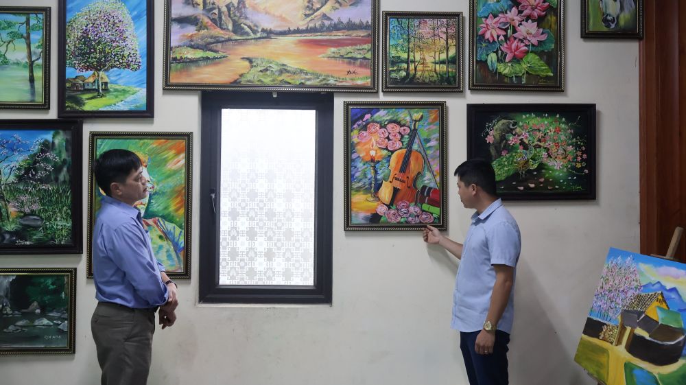 Anh Cao Thanh Nam dang gioi thieu nhung buc tranh cua minh cho khach den xem. Anh: Thanh Trung.