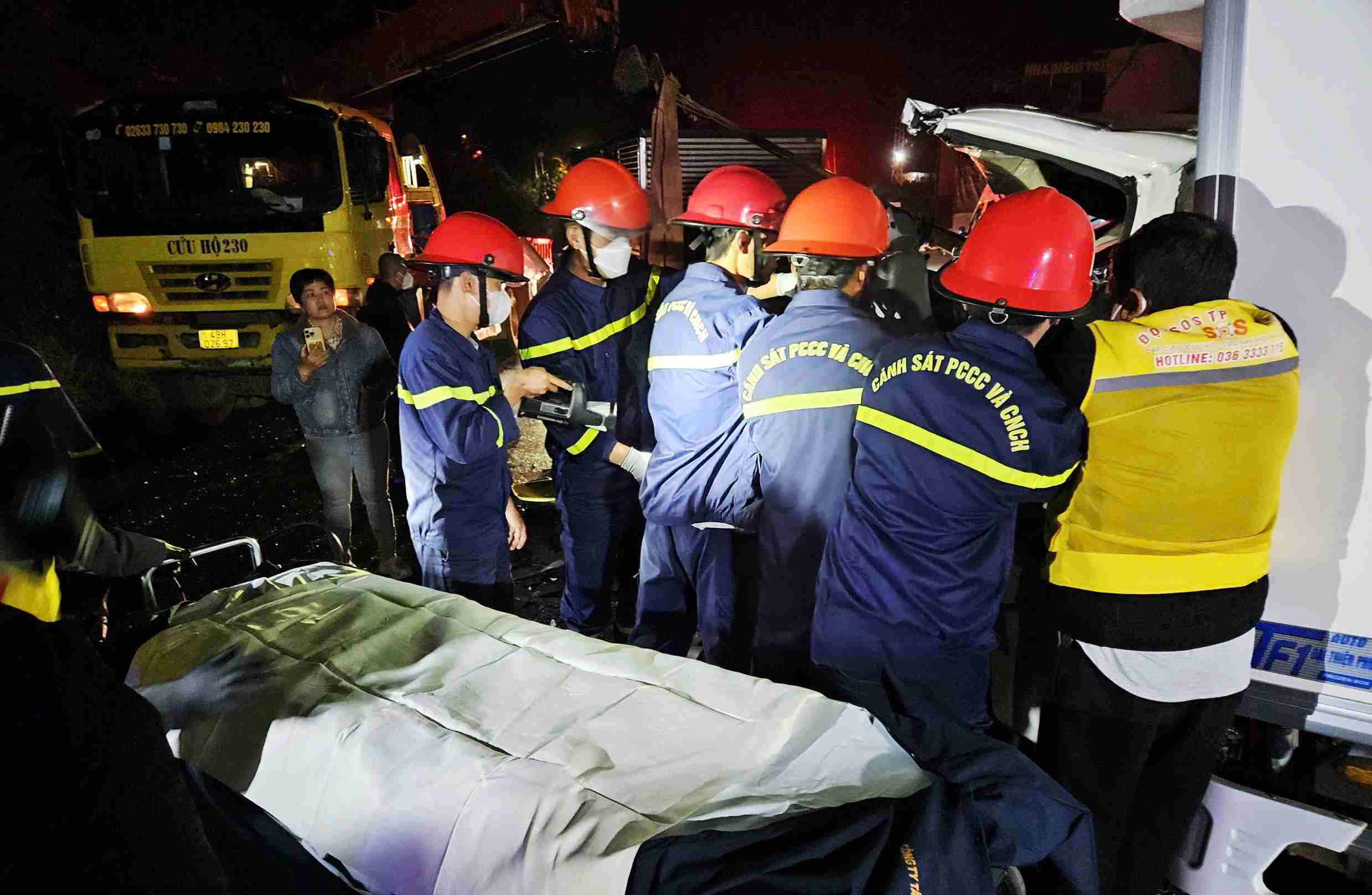 Phai mat hon 20 phut, luc luong cuu ho moi dua duoc tai xe va phu xe mac ket trong cabin xe tai 49B-098.54 ra ngoai. Anh: Nguyen Quan 