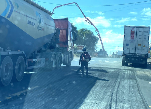 Cao boc mat duong de tham lai be tong nhua. Anh: Thanh Tuan 