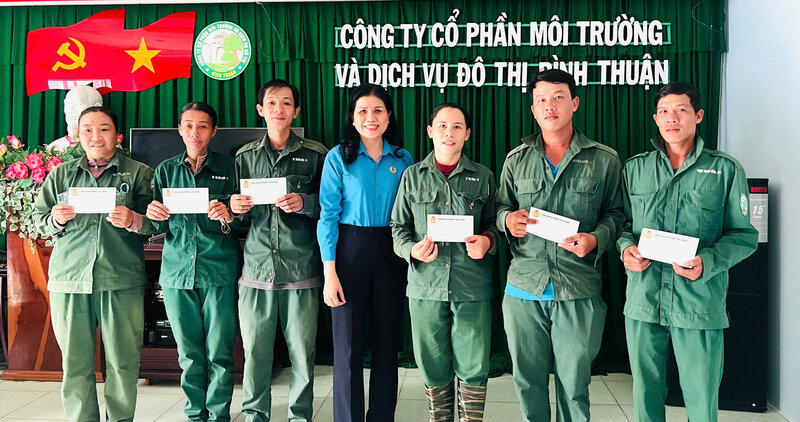 Mme Dao Thi Ha Ny - Presidente du syndicat du quartier de Tien Thanh (au milieu) offre des cadeaux du Tet aux membres du syndicat et aux travailleurs de la societe par actions d'environnement et de services urbains de Binh Thuan. Photo: Lam Duc