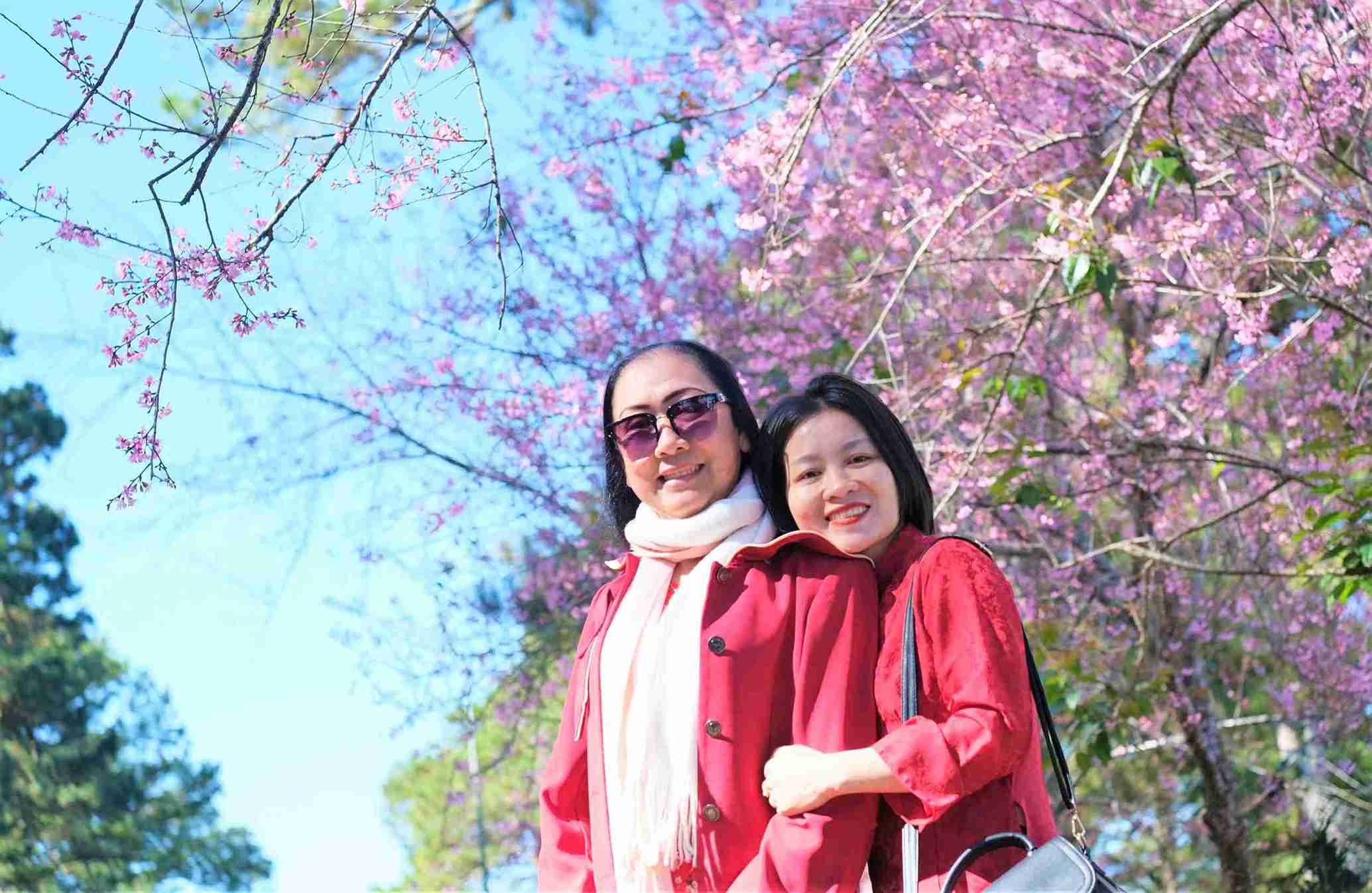 Hai mẹ con nữ du khách đến từ TP Hồ Chí Minh cùng tận hưởng hạnh phúc bên hoa mai anh đào khi đến Đà Lạt. Ảnh: Phúc Khánh