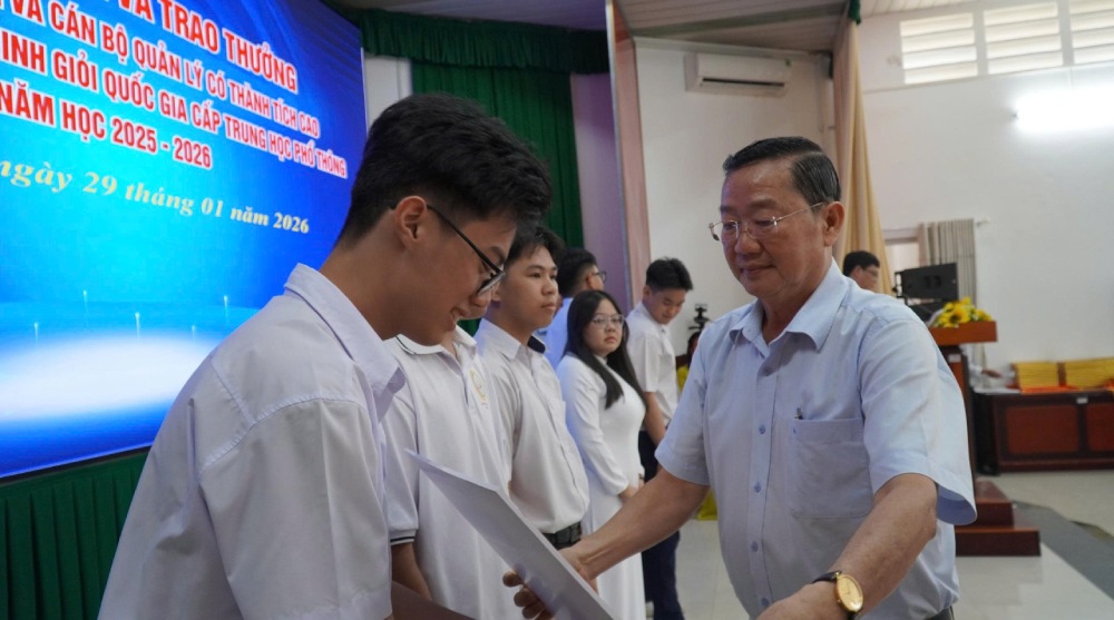 Giám đốc Sở Giáo dục và Đào tạo tỉnh An Giang Trần Quang Bảo trao thưởng cho các em học sinh. Ảnh: Văn Sĩ