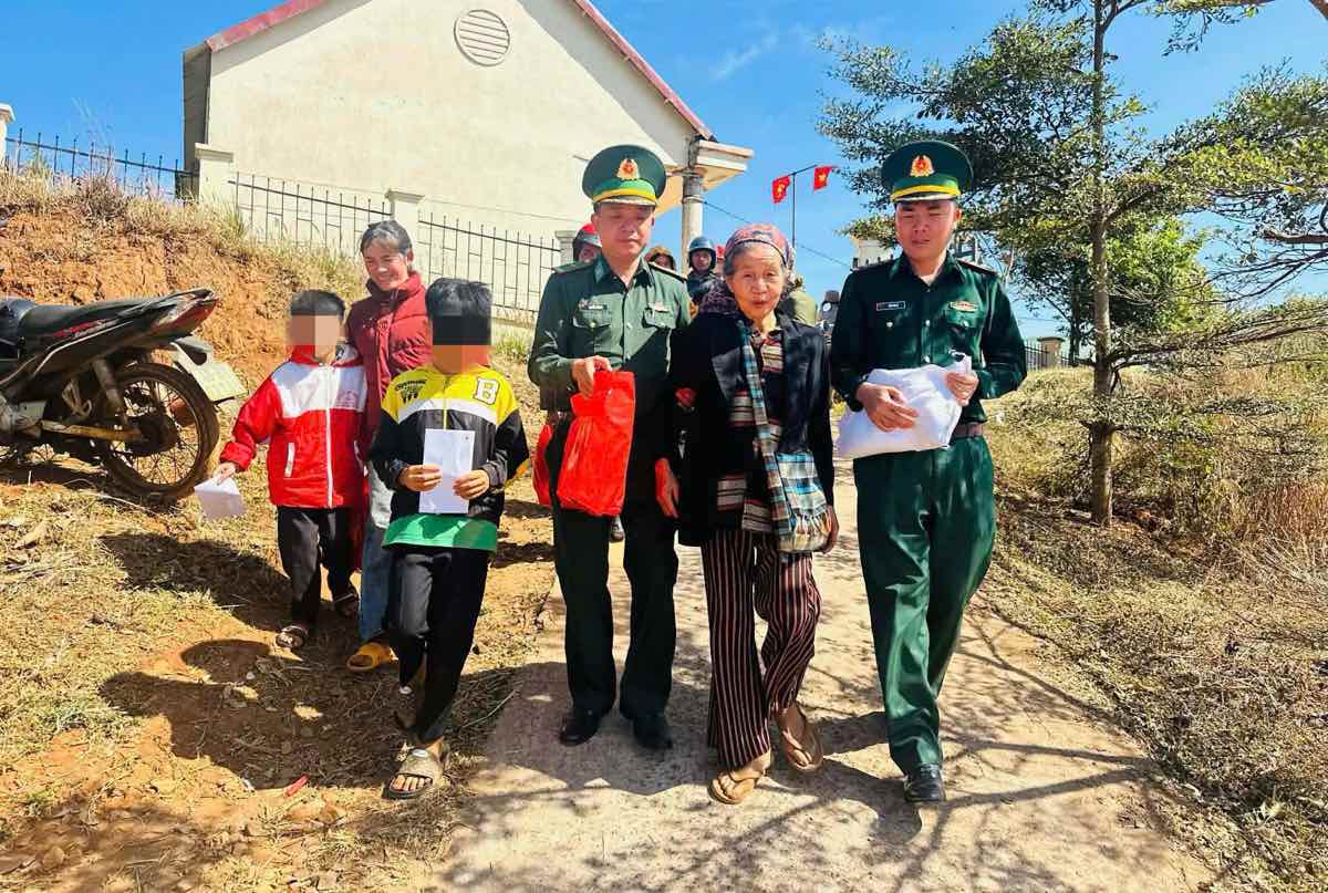 Cán bộ Đồn biên phòng Đắk Dang hỗ trợ người dân mang quà về nhà. Ảnh: Linh Khôi