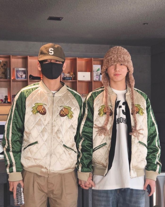 V và Jungkook nắm tay, mặc áo khoác đôi. Ảnh: Lotte