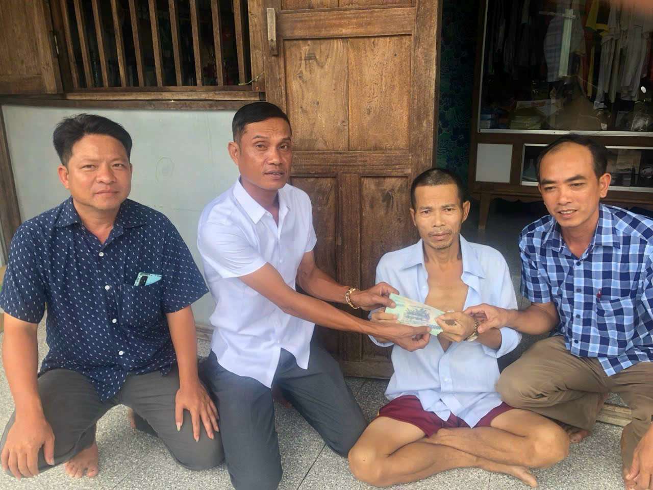 Ông Danh Tre, trao tiền hỗ trợ cho gia đình khó khăn trong ấp.Ảnh: Nhân vật cung cấp.