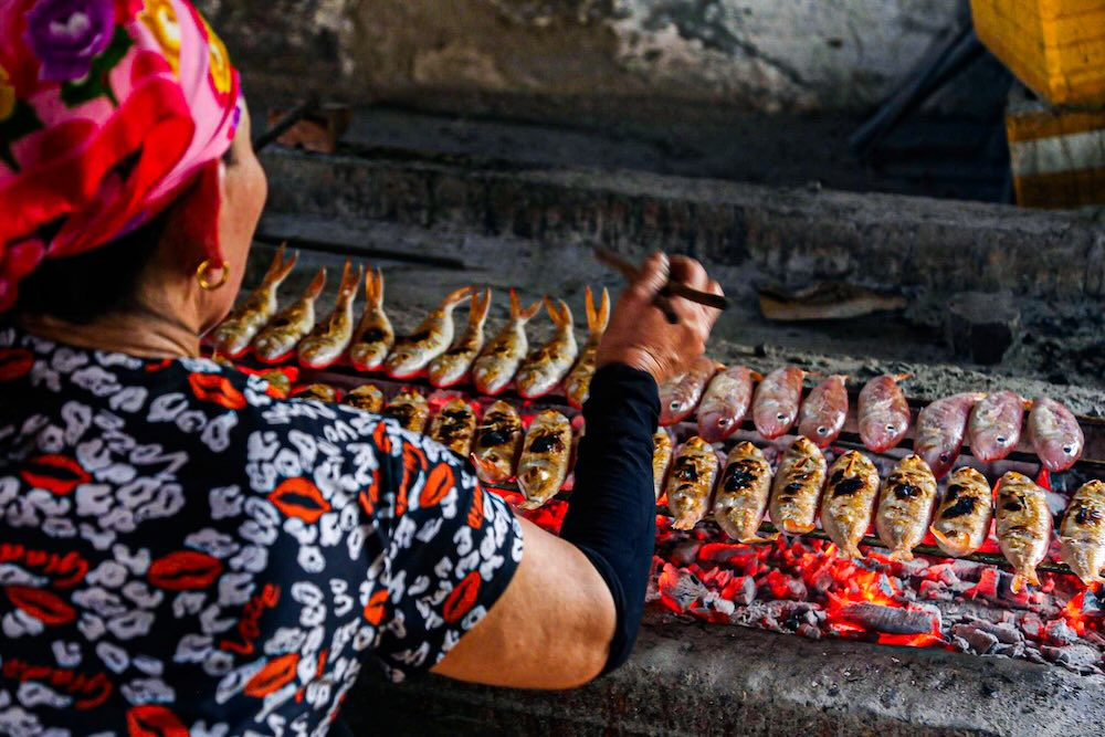 Đôi tay thoăn thoắt lật cá của người thợ nướng với hàng chục năm kinh nghiệm.