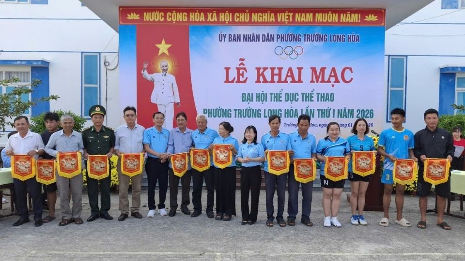 The Organizing Committee presents souvenir flags at the opening ceremony of the 1st Long Hoa Ward Physical Education and Sports Festival in 2026. Photo: Hoang Loc
