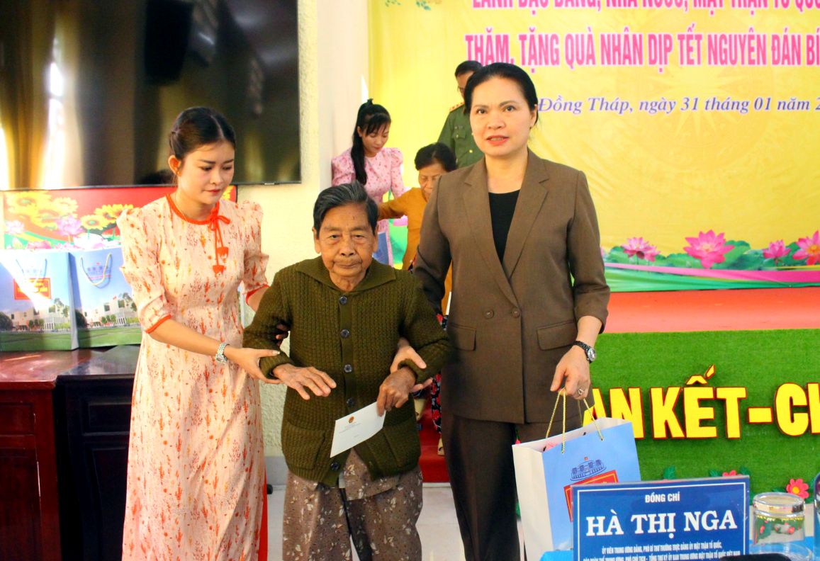 Bà Hà Thị Nga - Ủy viên Trung ương Đảng, Phó Bí thư Thường trực Đảng ủy Mặt trận Tổ quốc, các đoàn thể Trung ương, Phó Chủ tịch – Tổng Thư ký Ủy ban Trung ương Mặt trận Tổ quốc Việt Nam ân cần trao tặng quà Tết cho cụ bà thuộc diện gia đình chính sách. Ảnh: Thanh Mai