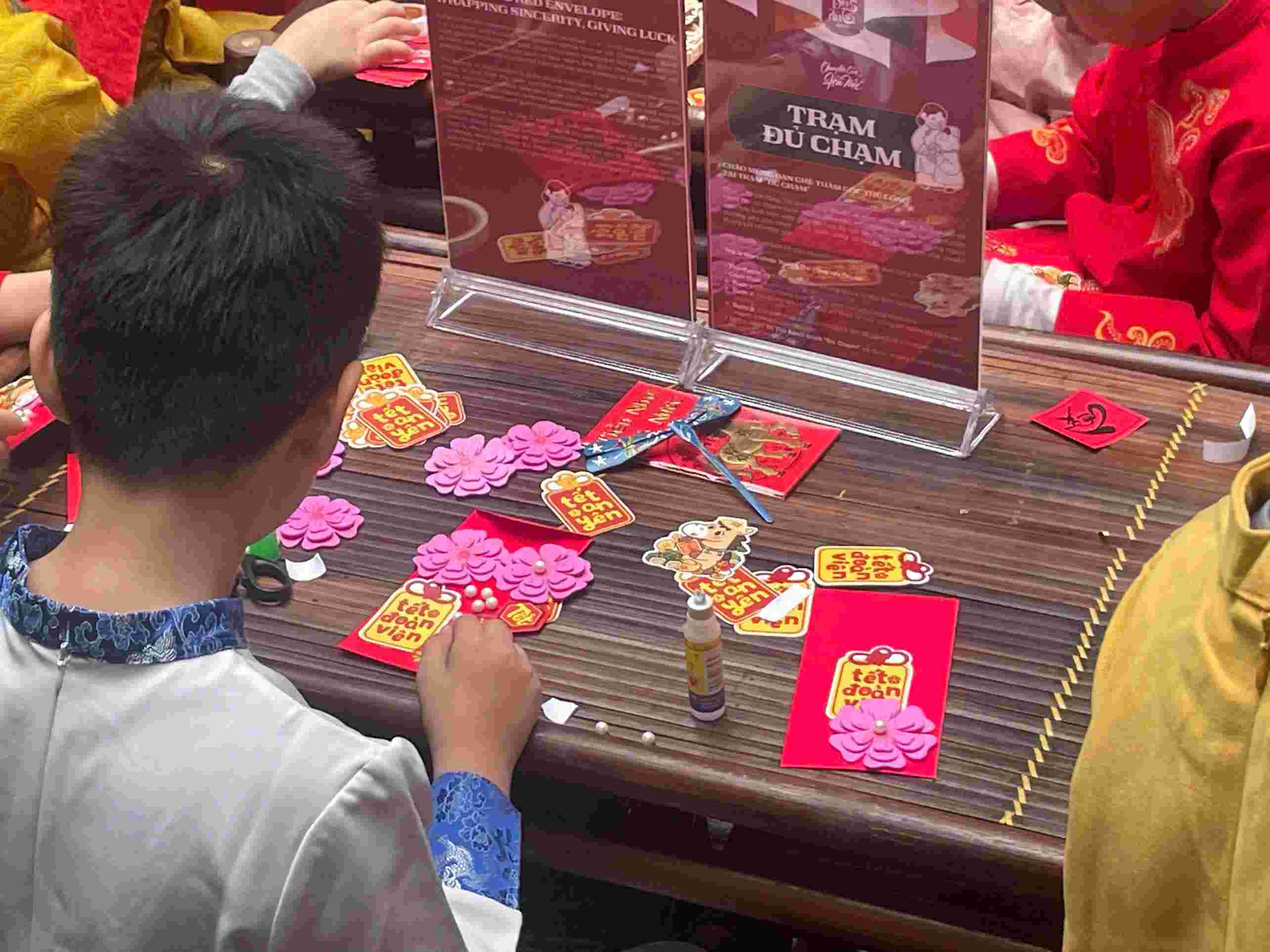 Những phong bao lì xì được các em học sinh tự tay dán và gửi gắm bên trong là niềm vui, ước mơ và háo hức đón Tết đang đến rất gần. Ảnh: Minh Vũ