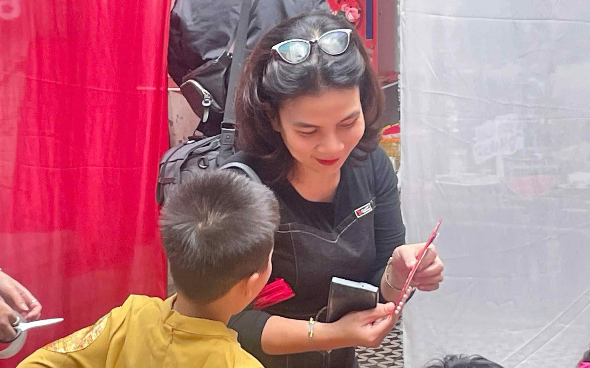 Cô giáo tận tình hướng dẫn các em học sinh tạo nên những phong bao lì xì nhỏ xinh, đầy ắp niềm vui và không khí Tết. Ảnh: Minh Vũ.