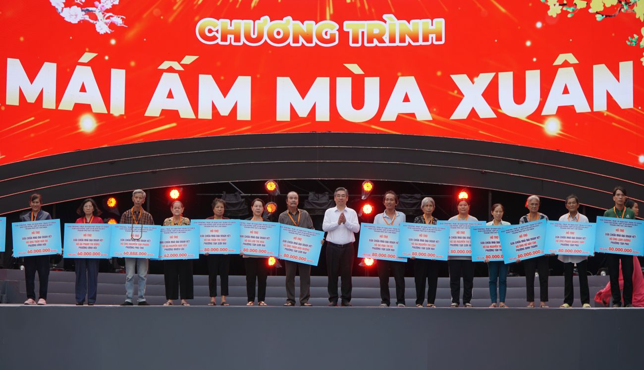 Các hộ dân nhận bảng tượng trưng kinh phí hỗ trợ xây dựng, sửa chữa nhà.  Ảnh: Thanh Chân