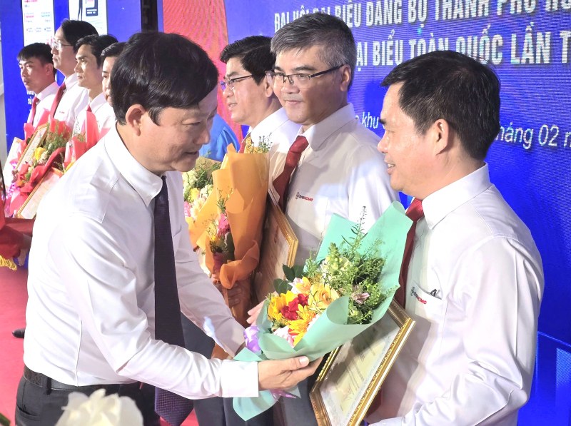 Ông Võ Văn Minh - Ủy viên Trung ương Đảng, Phó Bí thư Thành ủy, Chủ tịch HĐND TPHCM - trao thưởng và tạng hoa cho các tập thể, cá nhân có thành tích tiêu biểu trong xây dựng lưới điện thông minh tại Côn Đảo. Ảnh: Nam Dương 