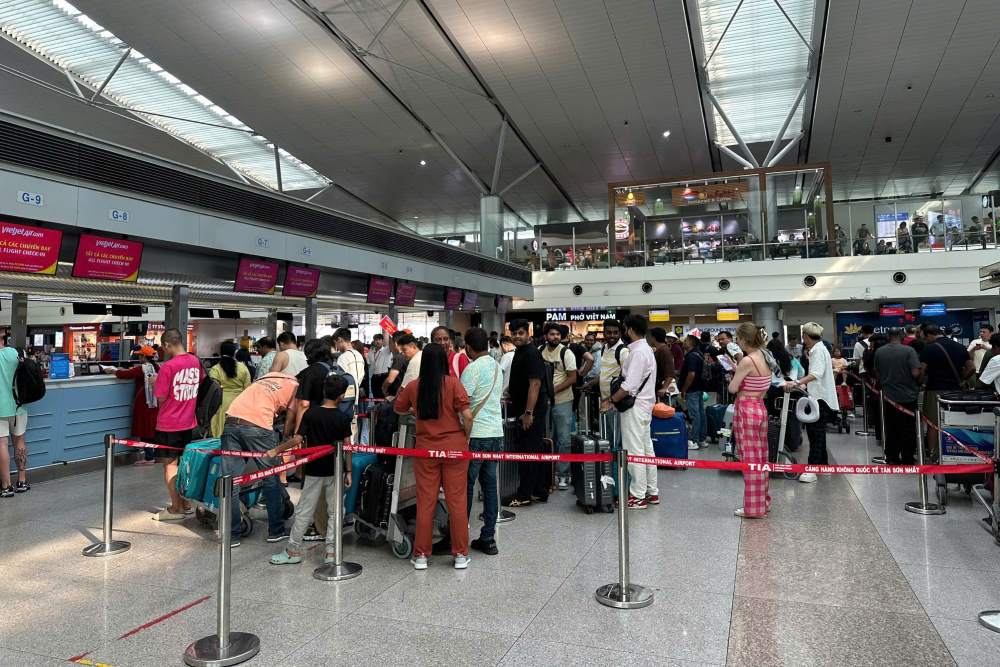 Khu vuc lam thu tuc xuat canh nhon nhip dong khach roi Viet Nam. Luong khach quoc te bay di hom nay van giu o muc cao, chua co dau hieu ha nhiet.