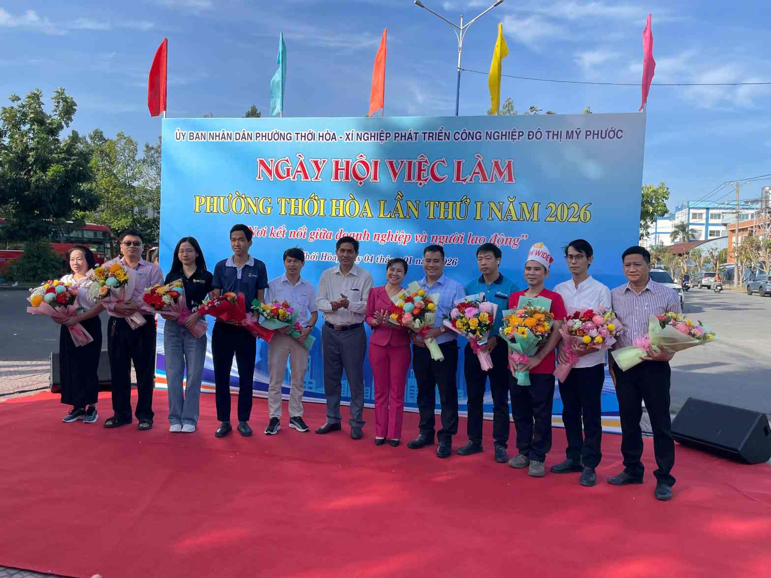 Ban to chuc tang hoa cam on cac doanh nghiep tham gia ngay hoi. Anh: Dinh Trong