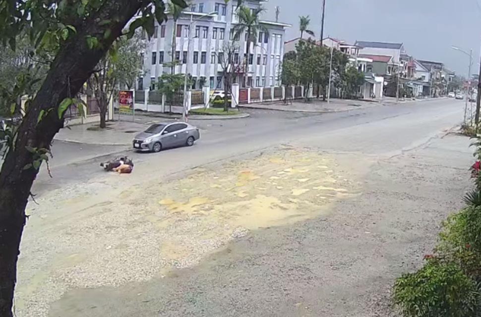 Người phụ nữ ngã xe môtô suýt bị xe con đâm trúng. Ảnh cắt từ camera.