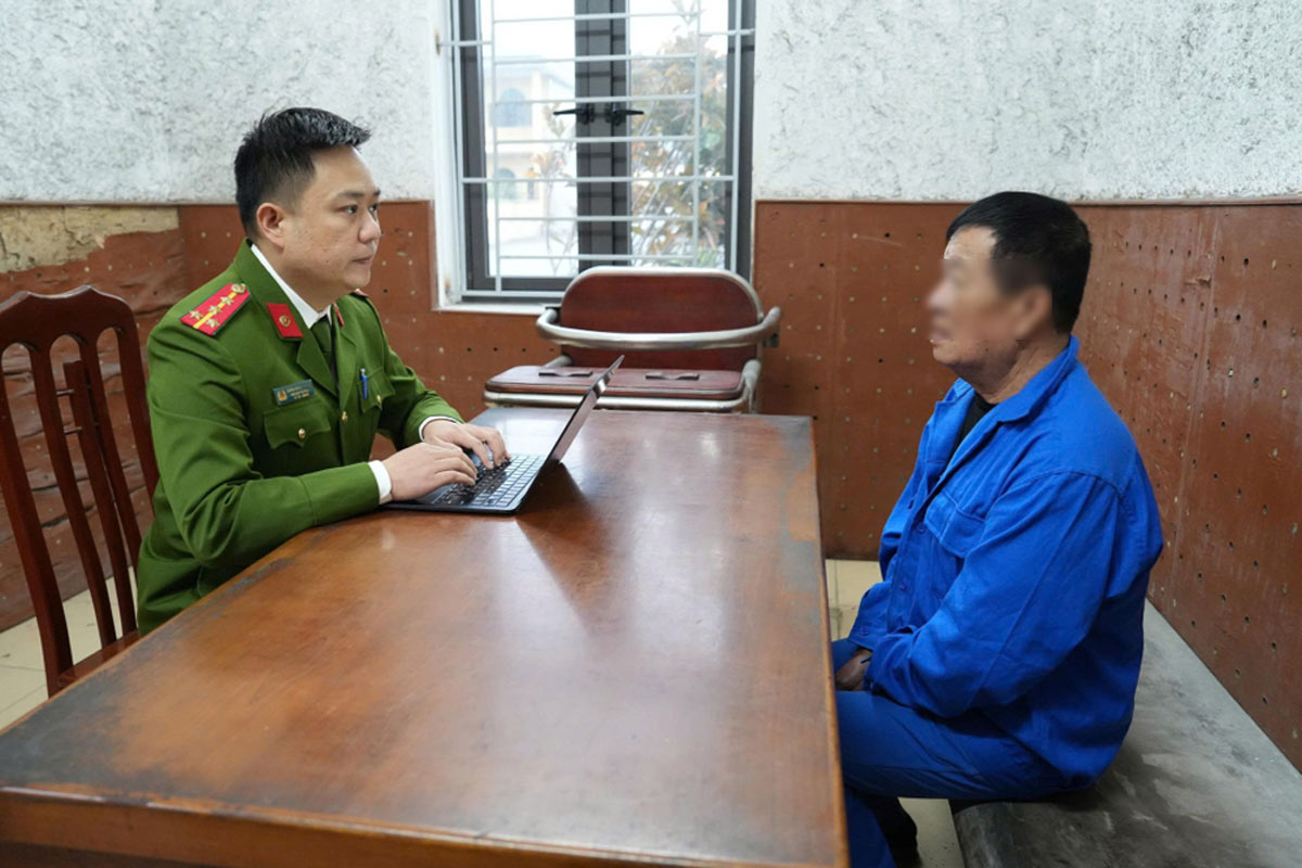 Cán bộ điều tra lấy lời khai đối tượng chủ mưu Nguyễn Đình Minh. Ảnh: Công an Quảng Ninh