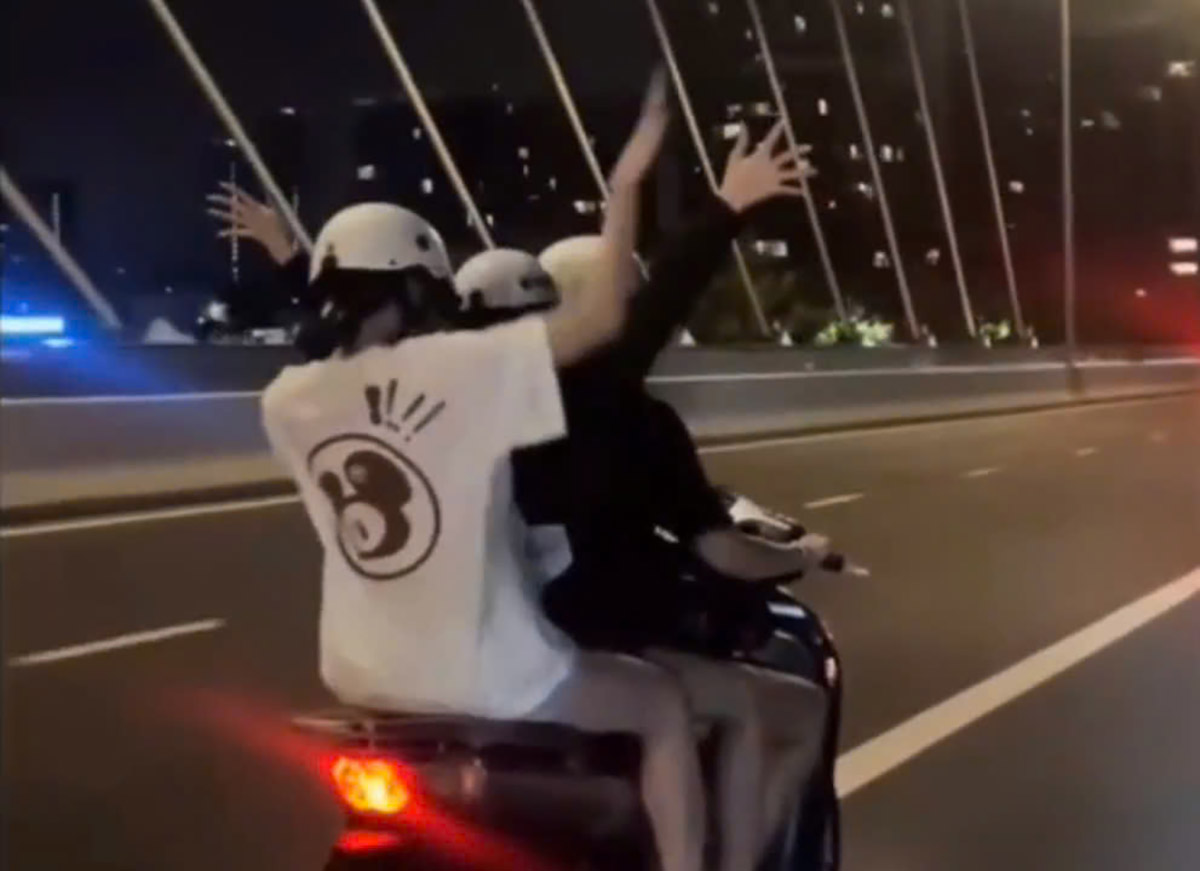 Clip recording the scene of a group of women carrying their father on an SH motorbike running on Ba Son bridge. Photo cut from clip