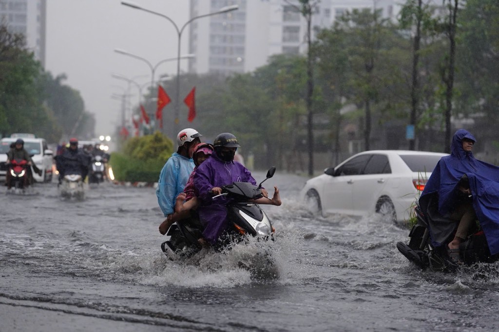 Thoi diem mua lon trung voi gio tan hoc, nhieu hoc sinh va phu huynh khi don con ve chat vat di chuyen. Anh: Minh Tam